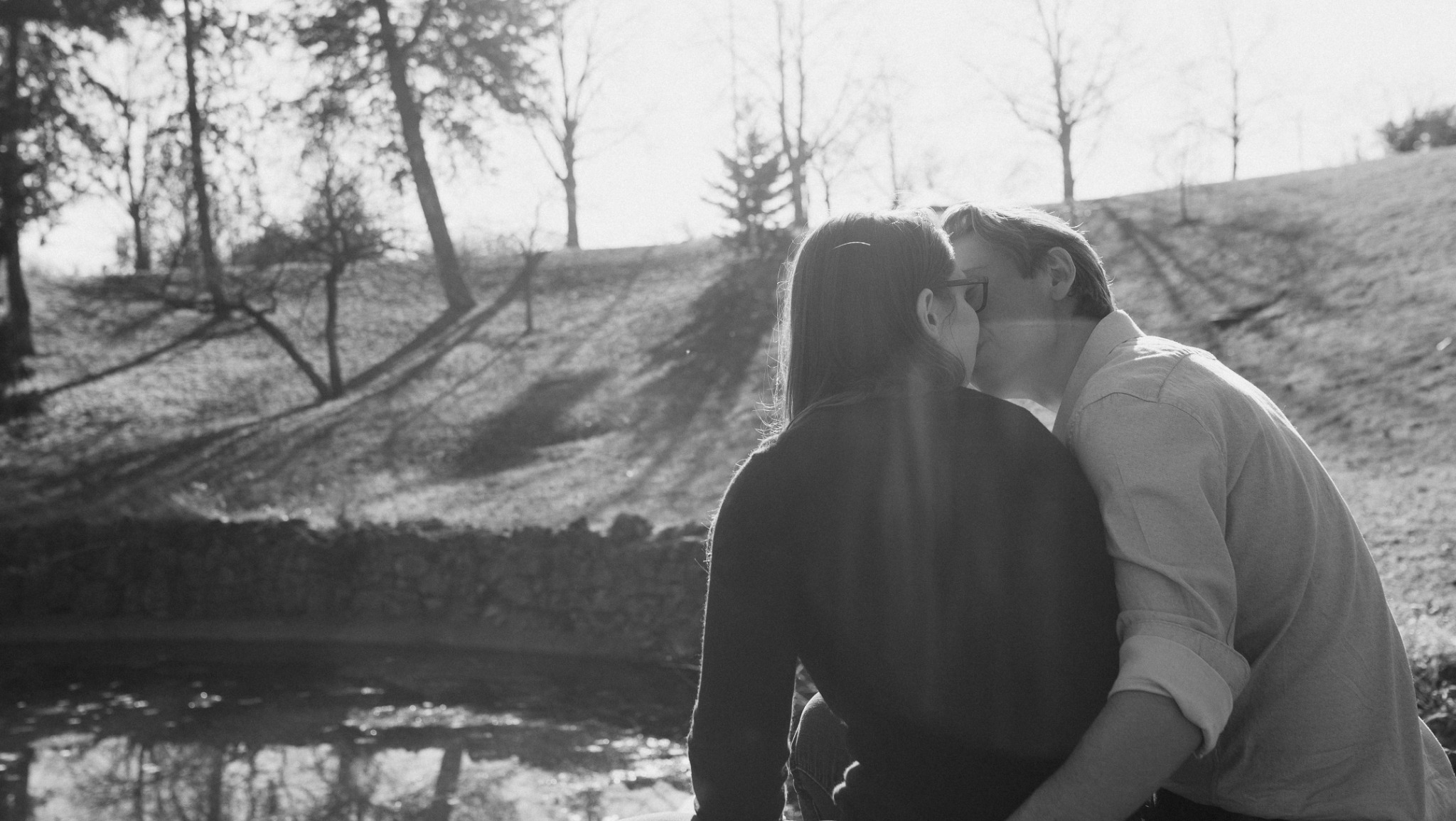 James and Rebecca kissing near the water